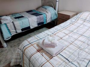 uma cama com duas toalhas num quarto em La Ponderosa em Caleta Olivia