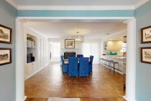 uma sala de estar com cadeiras azuis e uma cozinha em Coastal Dream - 2232 Ocean Rd em Saint Simons Island