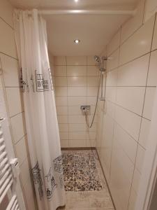 a bathroom with a shower with a shower curtain at Entspannung unter Reet in Bordelum