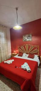 ein rotes Schlafzimmer mit einem Bett mit Handtüchern darauf in der Unterkunft Le Stelle Del Tirreno in Falcone