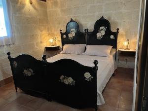 ナルドにあるCase Vacanze Agriturismo Fontanellaのベッドルームに花の咲く黒いベッド