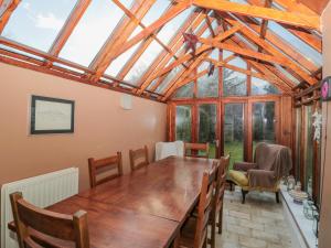 a conservatory with a wooden table and chairs at 2 The Reformed Church in Alnwick