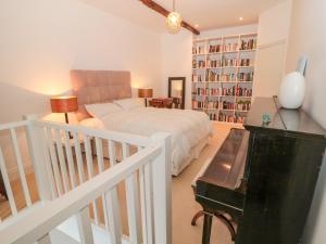 a bedroom with a bed and a piano at 2 The Reformed Church in Alnwick