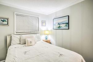 Un dormitorio con una cama blanca y una ventana. en Cozy Myrtle Beach Escape with Resort Amenities!, en Myrtle Beach 30 fotos más