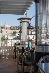 a table and chairs on a balcony with a view of the city at Casa 1810 Hotel Boutique in San Miguel de Allende