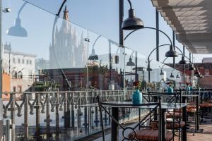 a patio with tables and chairs and a view of a city at Casa 1810 Hotel Boutique in San Miguel de Allende