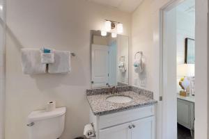 een badkamer met een wastafel, een toilet en een spiegel bij 400 Ocean King Suite in King City