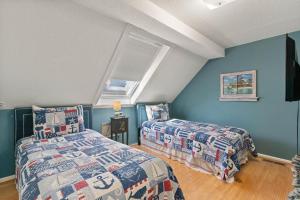 - 2 lits dans une chambre aux murs bleus dans l'établissement Beachcomber, Unit 302, à Demere Park