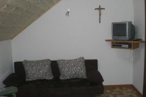 a living room with a black couch and a tv at Pirchnerhof in Longomoso