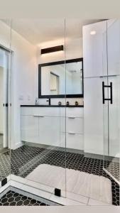 a bathroom with a glass shower with a mirror at Stunning Downtown Penthouse w Roof Deck, Fire Pit, Free Parking in Austin