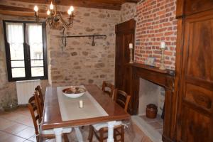 a dining room with a table and a brick wall at Le four à pain in Najac