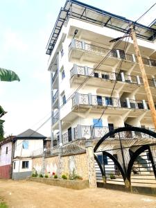 a white building with a bridge in front of it at APEX ANNEX Guest Facility in Buea