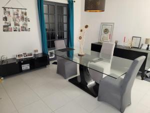 a dining room with a glass table and chairs at Chez Aurélie in Brest