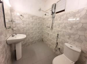un baño con inodoro y lavabo en Allen Lilly Ahangama, en Ahangama