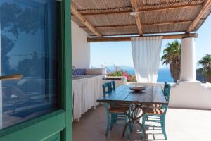 a table and chairs on a patio with a view of the ocean at Le Sette Sorelle in Filicudi