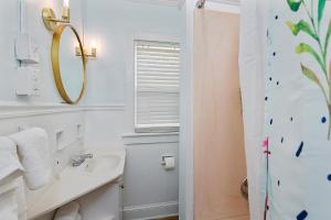a white bathroom with a sink and a mirror at Waterside - 829 Park Way in Saint Simons +15 photos