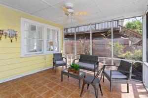 a screened in porch with chairs and a ceiling fan at Waterside - 829 Park Way in Saint Simons