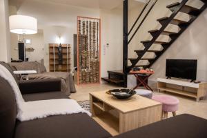 ein Wohnzimmer mit einem Sofa und einem TV in der Unterkunft Maison d' Alice 1 in Tríkala