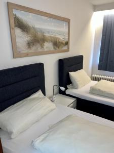 a bedroom with two beds and a picture of a beach at Gästehaus Rheinstetten Forchheim in Rheinstetten