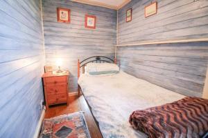 małą sypialnię z łóżkiem i drewnianą ścianą w obiekcie Granite Country Cottage west of Penzance w mieście Sancreed