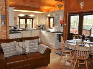 a living room with a couch and a table in a kitchen at Cairnhill Lodge - Award-Winning Luxury Highland Retreat in Blairgowrie +27 photos