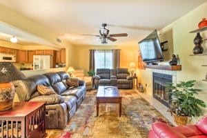 een woonkamer met een leren bank en een open haard bij Pet-Friendly Tucson Home with Heated Pool and Hot Tub in Tucson