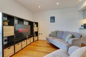 a living room with two couches and a flat screen tv at Heart of the City - Fantastic, Spacious 2 Bed Apartment, Netflix, Stunning Views, Sheffield City Centre in Sheffield