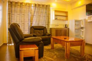 ROYAL ACACIA HOTEL ISIOLO في Tarbaj: غرفة معيشة مع أريكة وكرسي وطاولة