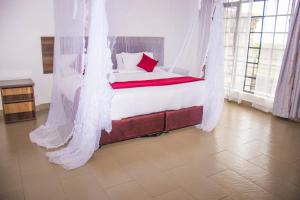 a bedroom with a bed with a mosquito net at ROYAL ACACIA HOTEL ISIOLO in Tarbaj