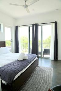 a bedroom with a bed and a large window at Luxury Penthouse w Glass Wall, Roof Deck, Firepit in DT Austin in Austin