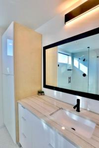 uma casa de banho com um lavatório e um espelho grande em Luxury Penthouse w Glass Wall, Roof Deck, Firepit in DT Austin em Austin
