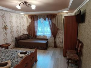 um quarto com uma cama, um sofá e uma janela em Гостинний двір у Ангеліни em Tatariv