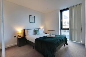 a bedroom with a bed and a large window at View of the City - Fantastic, Spacious 2 Bed Apartment, Netflix, Stunning Views, Sheffield City Centre in Sheffield