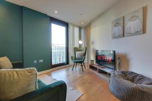 a living room with a couch and a television at View of the City - Fantastic, Spacious 2 Bed Apartment, Netflix, Stunning Views, Sheffield City Centre in Sheffield