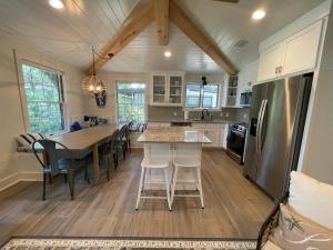 a kitchen with a table and chairs and a refrigerator at Tree Spirit Retreat - 4310 Third Street in Saint Simons Island