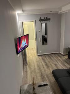 a living room with a flat screen tv on a wall at Apartment Home in NRW in Gladbeck