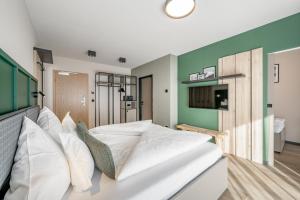 un grande letto bianco in una stanza con pareti verdi di The Moss - Your unique hideaway a Obergurgl