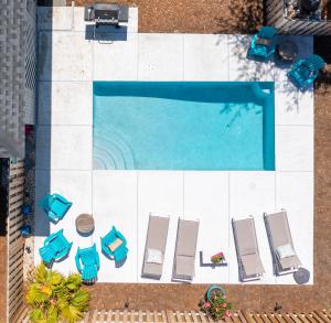 an overhead view of a swimming pool with chaises and chairs at Three Oaks Beach Cottage - 2215 Bruce Drive in Saint Simons Island