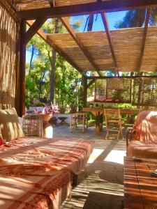 um pátio com uma pérgula de madeira com cadeiras e mesas em Sani Villa Haven em Sani Beach
