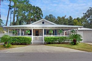 une maison blanche avec des palmiers devant elle dans l'établissement Everlasting Moon - 1204 George Lotson Avenue, à Demere Park