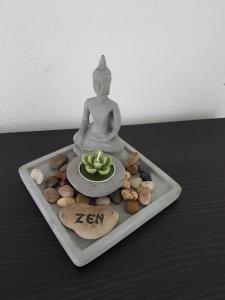 uma estátua de Buda sentada numa bandeja com um prato de comida em Brissago: 3.5 Zi-Wohnung an extrem ruhiger Lage mit fantastischem Ausblick em Brissago