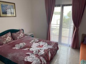 um quarto com uma cama com colcha floral em Apartments Plaza em Ulcinj