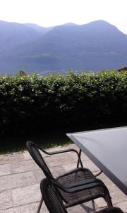 a table and a chair with a view of the water at Brissago: 3.5 Zi-Wohnung an extrem ruhiger Lage mit fantastischem Ausblick in Brissago