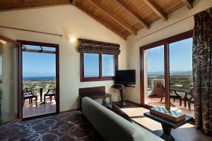 a living room with a couch and a television at Villa Koulouridi Agritourism in Daratso