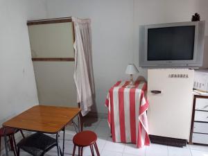 Zimmer mit einem Kühlschrank, einem Tisch und einem TV in der Unterkunft Habitación y dptos 1 y 2 amb con estacionamiento cerca del mar in Mar de Ajó