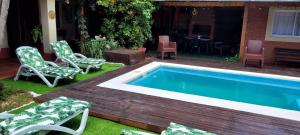 una piscina en un patio con sillas y mesa en Casa 24 Puerto Iguazu en Puerto Iguazú