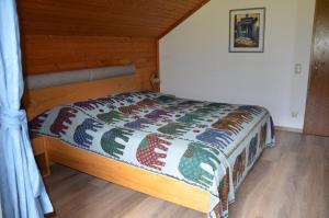 a bedroom with a bed with a quilt on it at Seehof Royer in Obertraun