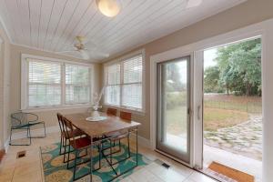 a dining room with a table and some windows at 44 Dune House - 1901 Dixon Lane in Saint Simons Island