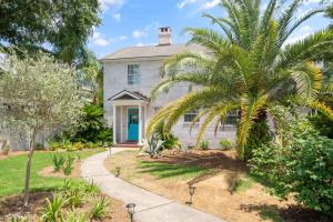 a house with a palm tree in front of it at 44 Dune House - 1901 Dixon Lane in Saint Simons Island