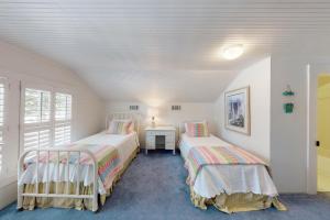 ein Zimmer mit zwei Betten und einem Tisch darin in der Unterkunft You are my Sunshine - 4213 Fifth Street in Saint Simons Island